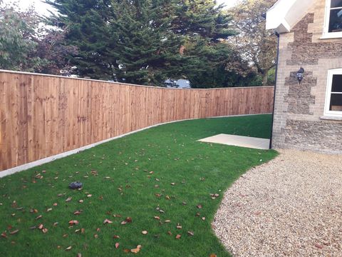 New close-board timber fence around a freshly laid lawn