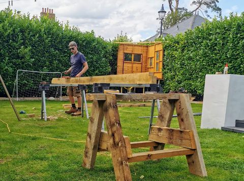 Matt Bizley working timber on sawhorses in a client's garden