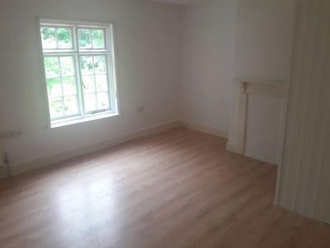 Laminate flooring fitted through a bright bedroom with period fireplace