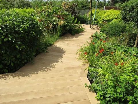 Timber decking path winding through a planted garden